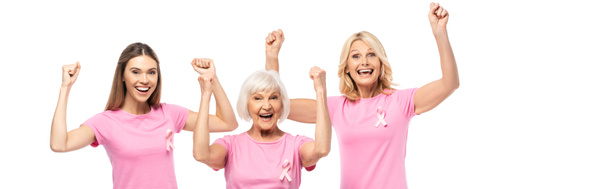 Horizontaal beeld van opgewonden vrouwen in t-shirts met linten van borstkankerbewustzijn, met ja-gebaar geïsoleerd op wit - Foto, afbeelding