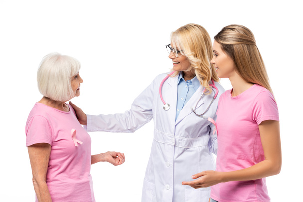 Orvos sztetoszkóppal nézi nő rózsaszín szalaggal n-shirt elszigetelt fehér - Fotó, kép