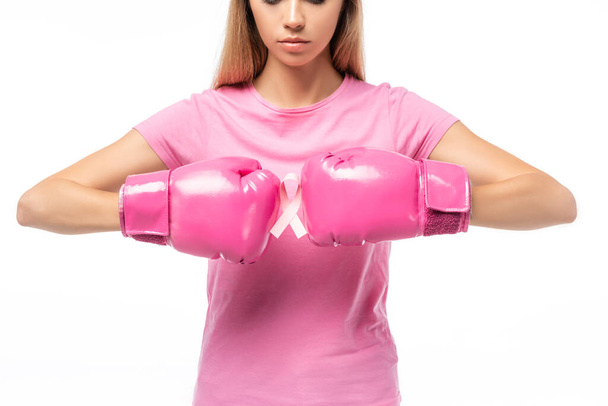 Cropped view of young woman in pink boxing gloves holding ribbon of breast cancer awareness isolated on white - Foto, afbeelding