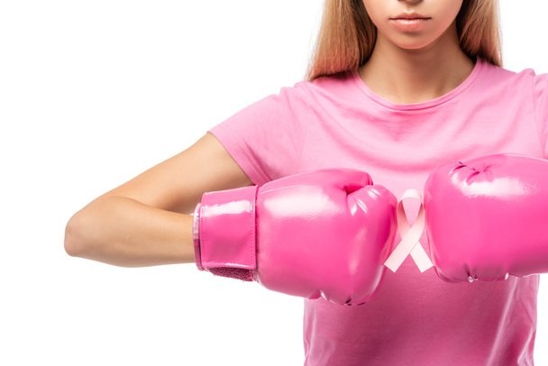 Vista recortada de una mujer joven con guantes de boxeo rosa sosteniendo cinta de conciencia de cáncer de mama aislado en blanco - Foto, Imagen