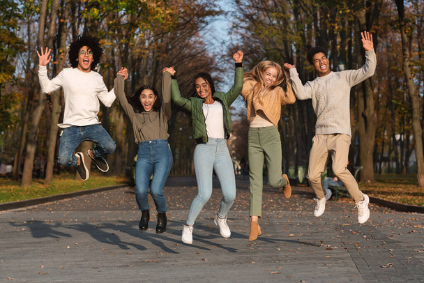 Estudantes despreocupados com as mãos para cima pulando no ar - Foto, Imagem