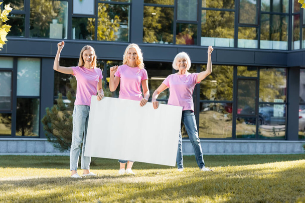 Women with yeah gestures holding empty board outdoors, concept of breast cancer - Photo, Image