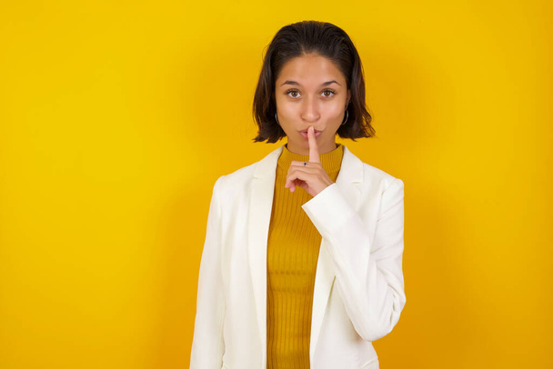 Don't tell my secret or not speak too loud, please! Emotional surprised student makes hush gesture, asks be quiet, has scared expression as afraid of revealing secret. - Photo, Image