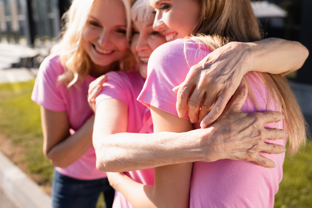 Selective focus of women in pink t-shirts hugging, concept of breast cancer - Zdjęcie, obraz