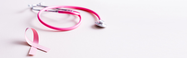 Panoramic shot of stethoscope and pink ribbon isolated on white - Foto, afbeelding
