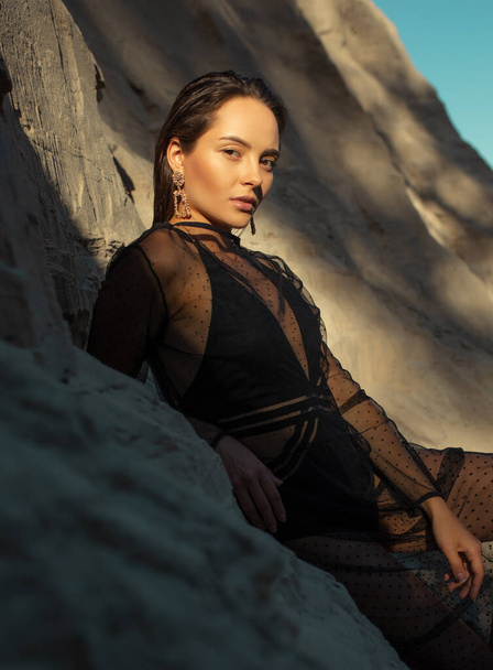 Csinos nő fekete átlátszó ruha pózol homok kanyon. - Fotó, kép