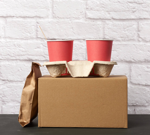 одноразові чашки червоного паперу стоять у лотку, білому фоні, контейнери для виймання
 - Фото, зображення