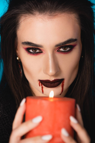 selective focus of woman with blood on face holding burning candle - Photo, Image
