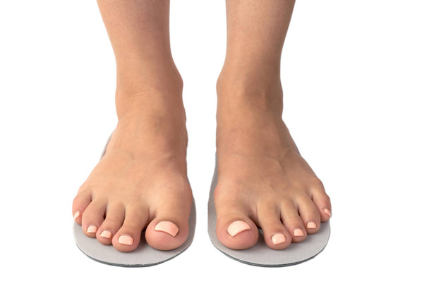 Weibliche Füße und Einlagen isoliert auf weißem Hintergrund. - Foto, Bild