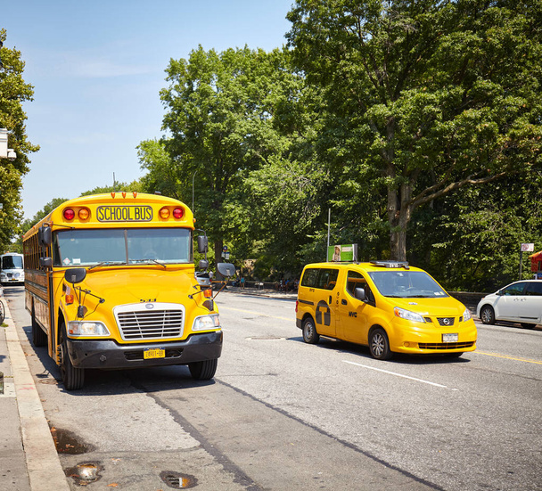 ニューヨーク、アメリカ- 2015年8月18日:マンハッタンの通りにスクールバスとタクシーの車両. - 写真・画像