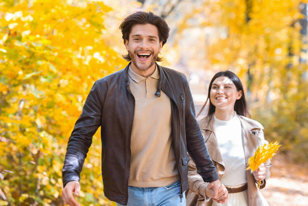 Emotional guy running buy golden forest with his girlfriend - Photo, Image