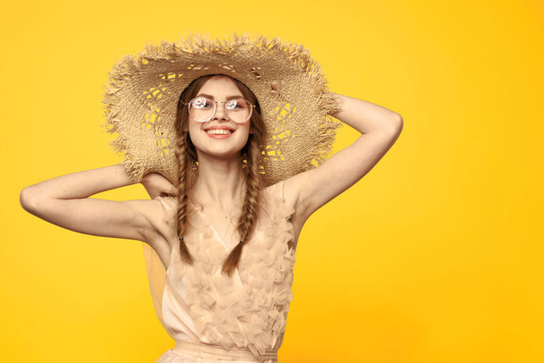 Πορτρέτο γυναίκα σε ψάθινο καπέλο σε κίτρινο φόντο περικοπή άποψη του μοντέλου φόρεμα καλοκαίρι ρομαντισμό κοτσίδες - Φωτογραφία, εικόνα