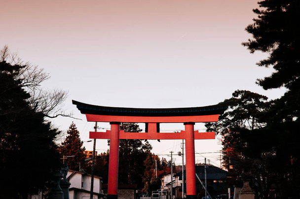 Porte Torii Grand Rouge au sanctuaire Morioka Hachimangu dans la préfecture d'Iwate au coucher du soleil avec un ciel ton chaud - région de Tohoku beau paysage et ville - Photo, image