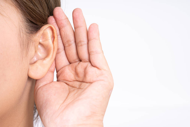 γυναίκα ακοή απώλεια ή δυσκολία στην ακοή και το αγκάλιασμα του χεριού της πίσω από το αυτί της απομονώσει σε λευκό φόντο, Κωφών έννοια. - Φωτογραφία, εικόνα