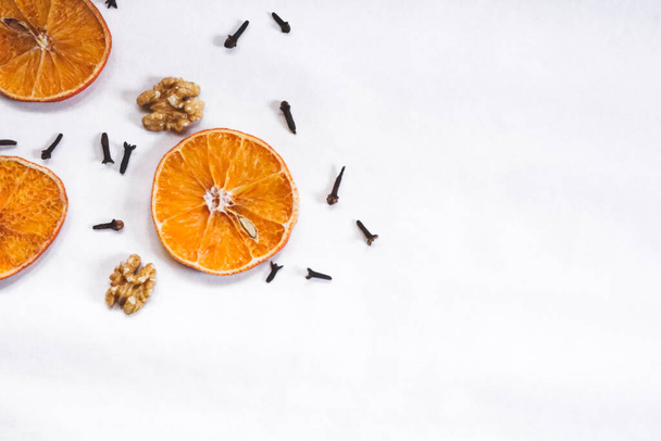 Oranges séchées avec des noix et clous de girofle disposition. Automne / hiver thème de fond. Bordure du coin depuis la vue du dessus, espace vide pour le texte. - Photo, image