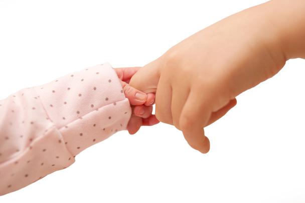 Bébé tenant doigt de l'enfant plus âgé
. - Photo, image