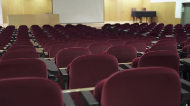 Κενό αμφιθέατρο σε Coronavirus Πανδημία Times. Μεγάλη αίθουσα συνεδριάσεων με κόκκινα βελούδινα καθίσματα - Πλάνα, βίντεο