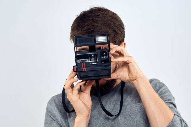 αρσενικό φωτογράφος κρατώντας φωτογραφική μηχανή επαγγελματικό φακό δημιουργικό στούντιο εργασίας φως φόντο - Φωτογραφία, εικόνα