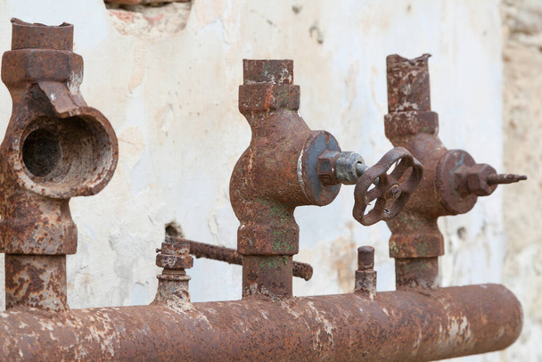Alte korrodierte Wasserleitung mit kaputten Armaturen im Freien - Foto, Bild