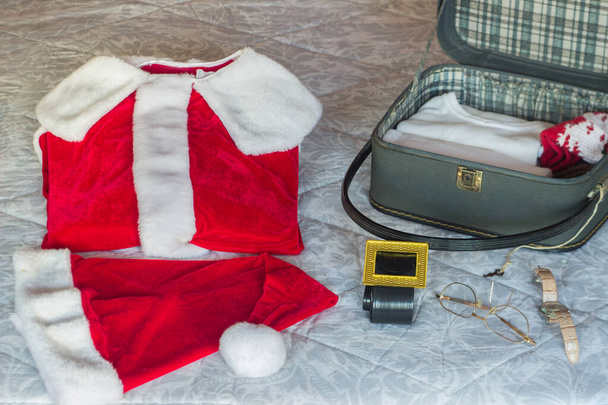 Valmistelee joulupukin matkalaukkua matkavaatteillaan. Valikoiva lähestymistapa. Joulun käsite - Valokuva, kuva
