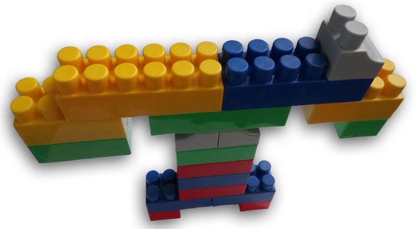 кран из игрушечной башни, собранный из цветных частей дизайнера на изолированном белом фоне - Фото, изображение