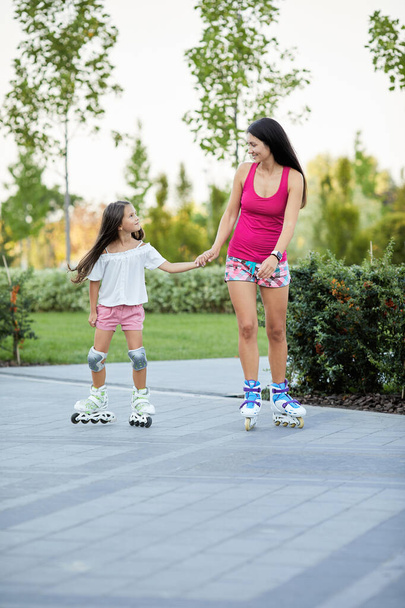 Young mother and her little daughter rollerskating - Foto, Imagem