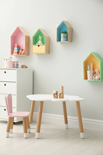 Children's room interior with house shaped shelves and little table - Photo, image