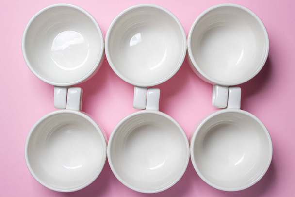 Белые чашки на розовом фоне. Много пустых чашек чая. - Фото, изображение