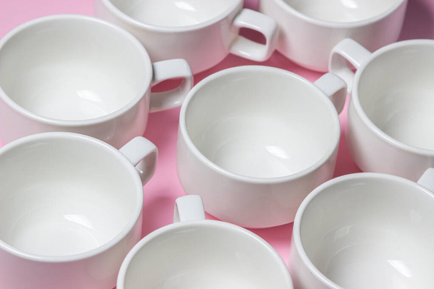Tasses blanches sur fond rose. Beaucoup de tasses à thé vides. - Photo, image