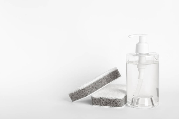 Bottle of detergent and sponges on white background - Foto, Imagen