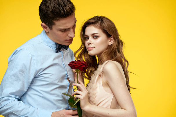 Зачарованные мужчина и женщина с красной розой на желтом фоне обрезанный вид крупным планом романтика - Фото, изображение