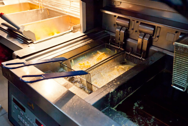 Готовить картошку фри во фритюрнице в ресторане - Фото, изображение