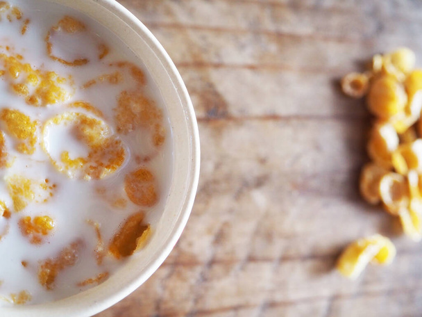 Frühstück in einer Tasse Milch auf einem Holztisch - Foto, Bild