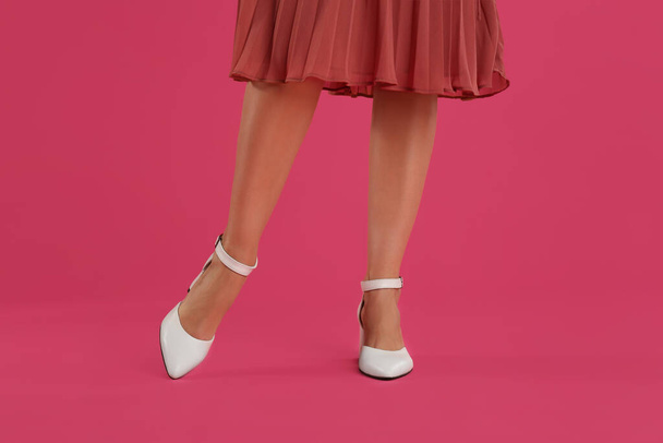 Woman wearing stylish shoes on pink background, closeup - Valokuva, kuva