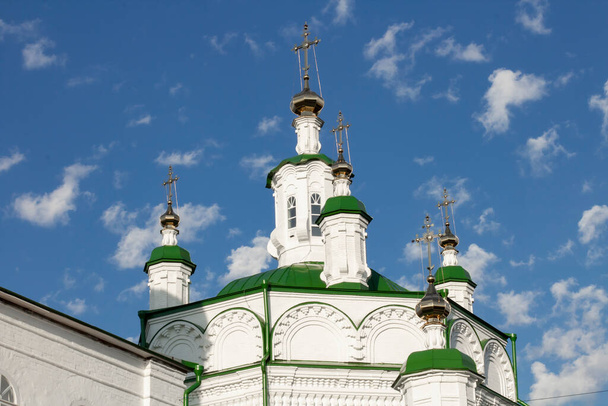 Domes and towers of the Orthodox Cathedral against the background of a blurred blue sky with light clouds. - Photo, image
