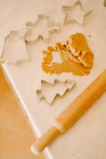 Proces výroby perníkových sušenek - váleček, formy a těsto na bílém stole. - Fotografie, Obrázek