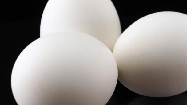Huevo de gallina blanco de cerca sobre fondo negro - Imágenes, Vídeo