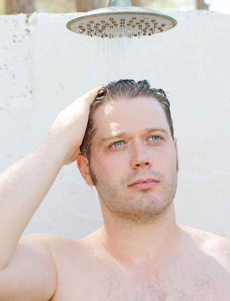 Attractive man having shower outdoors. - Foto, imagen