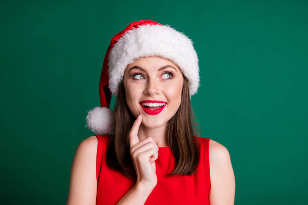 Closeup photo of attractive charming x-mas party lady look side up empty space arm chin dreamer wait miracle magic fireworks watch sky wear santa cap isolated green pastel color background - Foto, Imagem