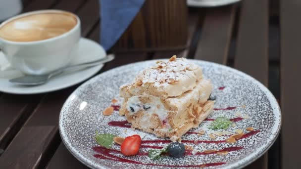 Вкусный десерт на тарелке в кафе на открытом воздухе - Кадры, видео