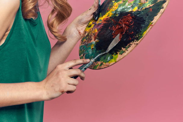 Femme artiste robe verte chevalet manger dessin art rose fond - Photo, image