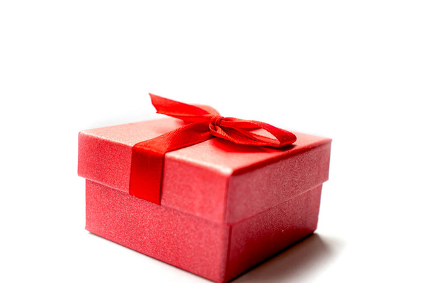 Rode geschenkdoos met rood lint voor de vakantie geïsoleerde item op witte achtergrond. - Foto, afbeelding