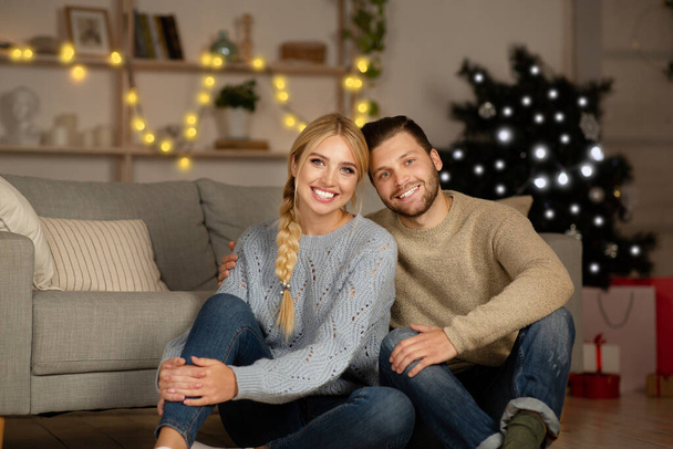 Hermosa pareja joven celebrando la Navidad juntos en casa - Foto, imagen