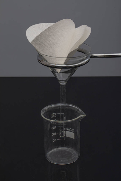 Suodatinpaperi laboratoriossa. Tutkijat ovat kemiallinen suodatus suodattamalla suodatinpaperin läpi lasisuppilossa, lähikuva - Valokuva, kuva