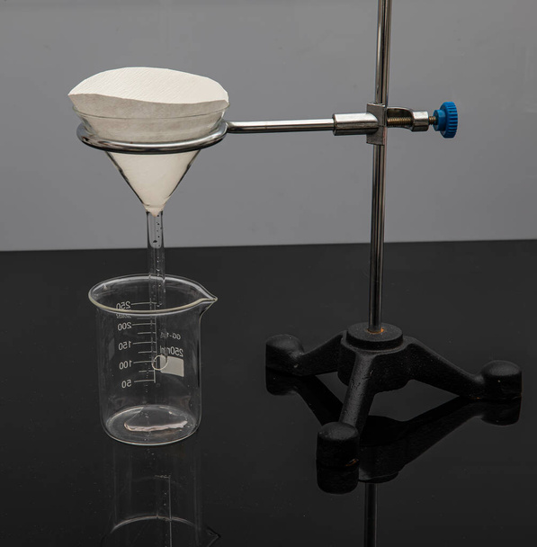 Papel filtrante en laboratorio. Los científicos son filtración química filtrando a través de papel de filtro en un embudo de vidrio, Primer plano - Foto, Imagen