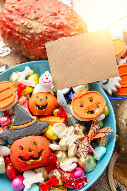 happy halloween card background, Jack o Lantern candy bowl with sweets and halloween cookies Trick or Treat surrounded by festive decor spiders, bats, skull - 写真・画像