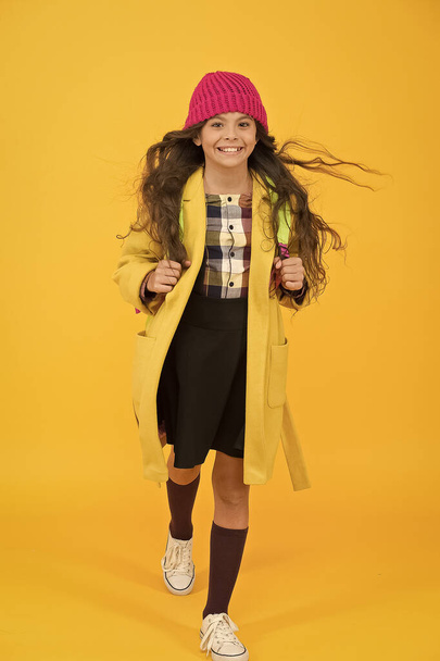 Happy walk. Fashion accessory. Fancy schoolgirl. Girl little fashionable pupil wear knitted hat and jacket. Modern outfit. Adorable schoolgirl winter outfit. Schoolgirl daily outfit with backpack - Fotó, kép