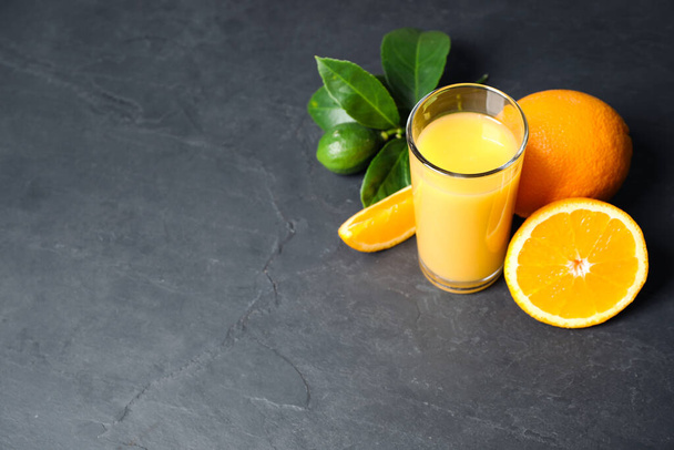 Glass of orange juice and fresh fruits on grey table. Space for text - Valokuva, kuva