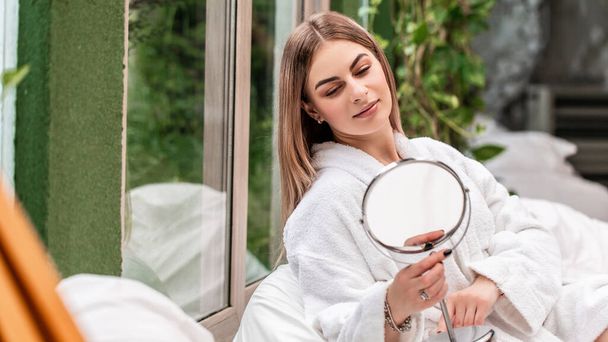 mothers day Young beautiful woman looking in the mirror. The concept of preserving the beauty of nature and youth. Spa and skin care. Long banner format. - Fotoğraf, Görsel