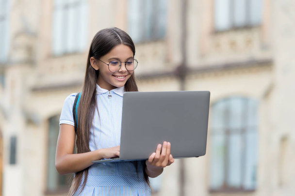 future successful programmer. knowledge day. kid learning private lesson. childrens blogging. happy smiling girl with laptop. Start up. child playing computer game. back to school. education online - Фото, изображение
